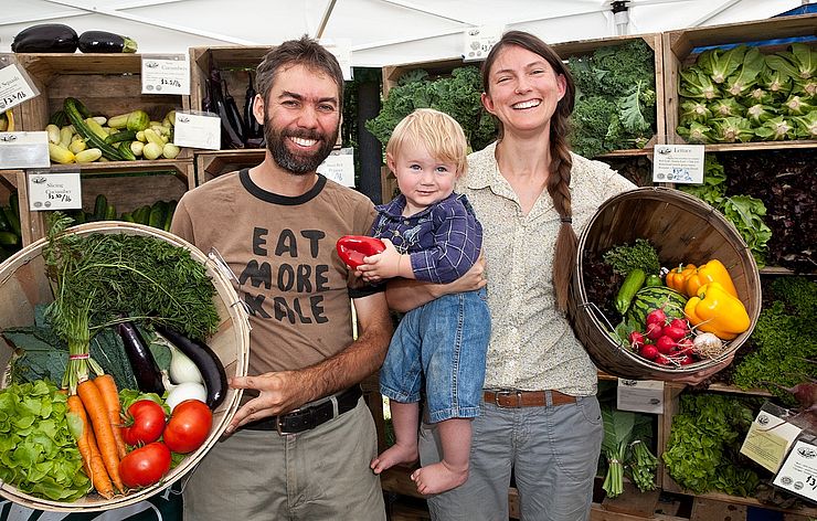Red Fire Farm owners Ryan and Sarah Voiland with their son at a farmers market