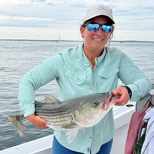 Emma Ellsworth holding striped bass