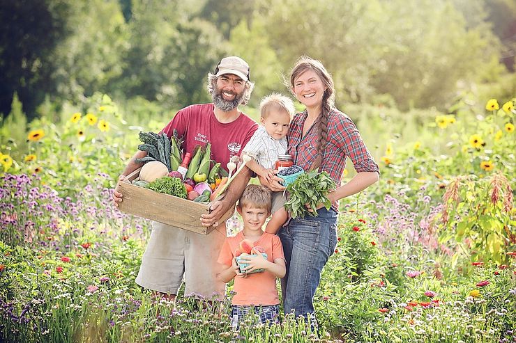 Red Fire Farm owners Ryan and Sarah Voiland with their family holding their bounty. 