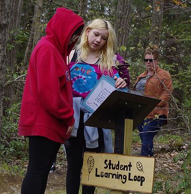 5th and 6th graders view the trailbook at the start of the learning loop trail.