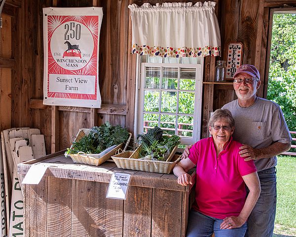 Sunset View Farm owners Chuck and Livvy Tarleton at their farm stand in Winchendon